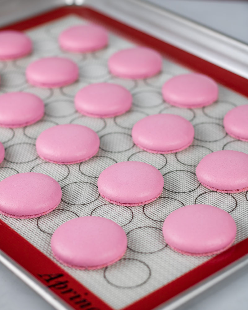 baked pink macaron shells on baking tray
